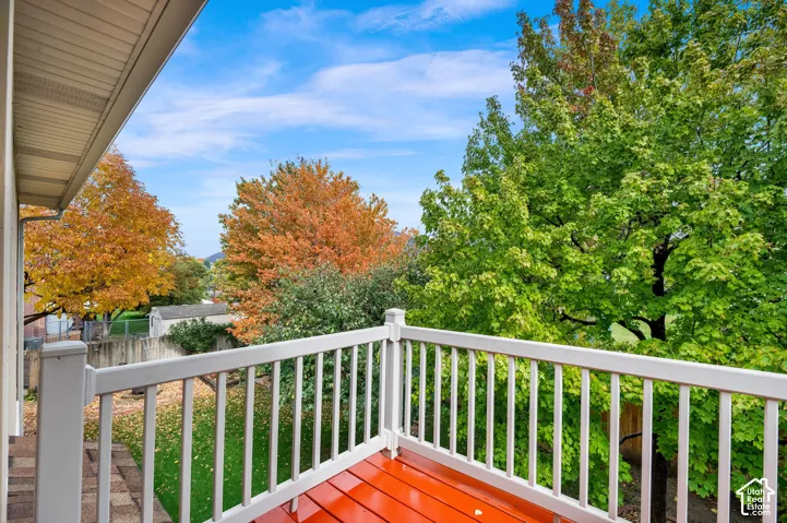 Elevated deck featuring white composite railings and finished wood-tone flooring