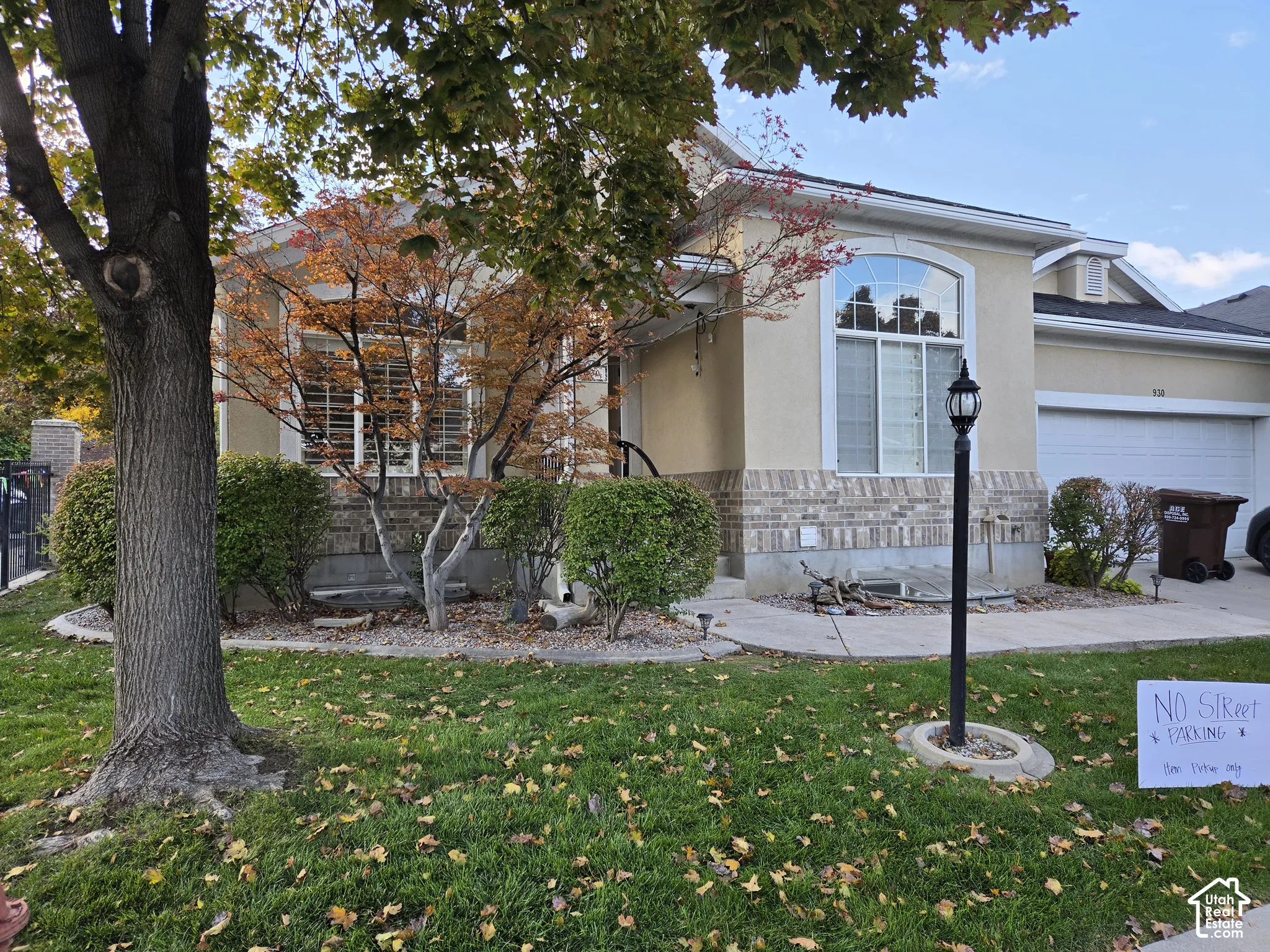 Stucco exterior featuring brick veneer accents, arched windows, and an attached two-car garage