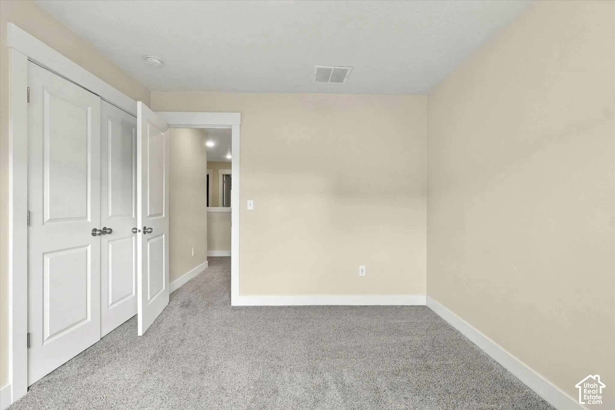 Bedroom featuring wall-to-wall carpeting and double-hung closet doors