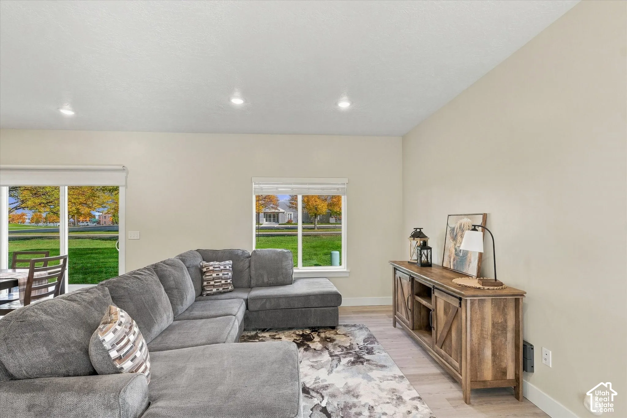 Neutral-toned interior featuring recessed lighting, light-colored wood-finish flooring, sliding glass patio doors, and picture windows