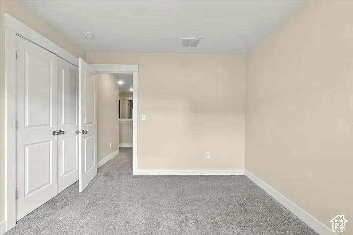 Bedroom featuring wall-to-wall carpeting and double-hung closet doors