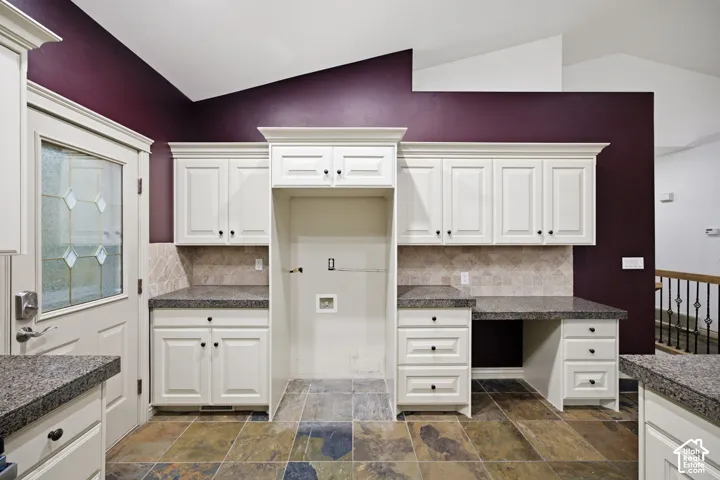 Kitchen featuring white shaker-style cabinetry, stone-finish countertops, diagonal tile backsplash, slate-finish floor tile, and a built-in workspace