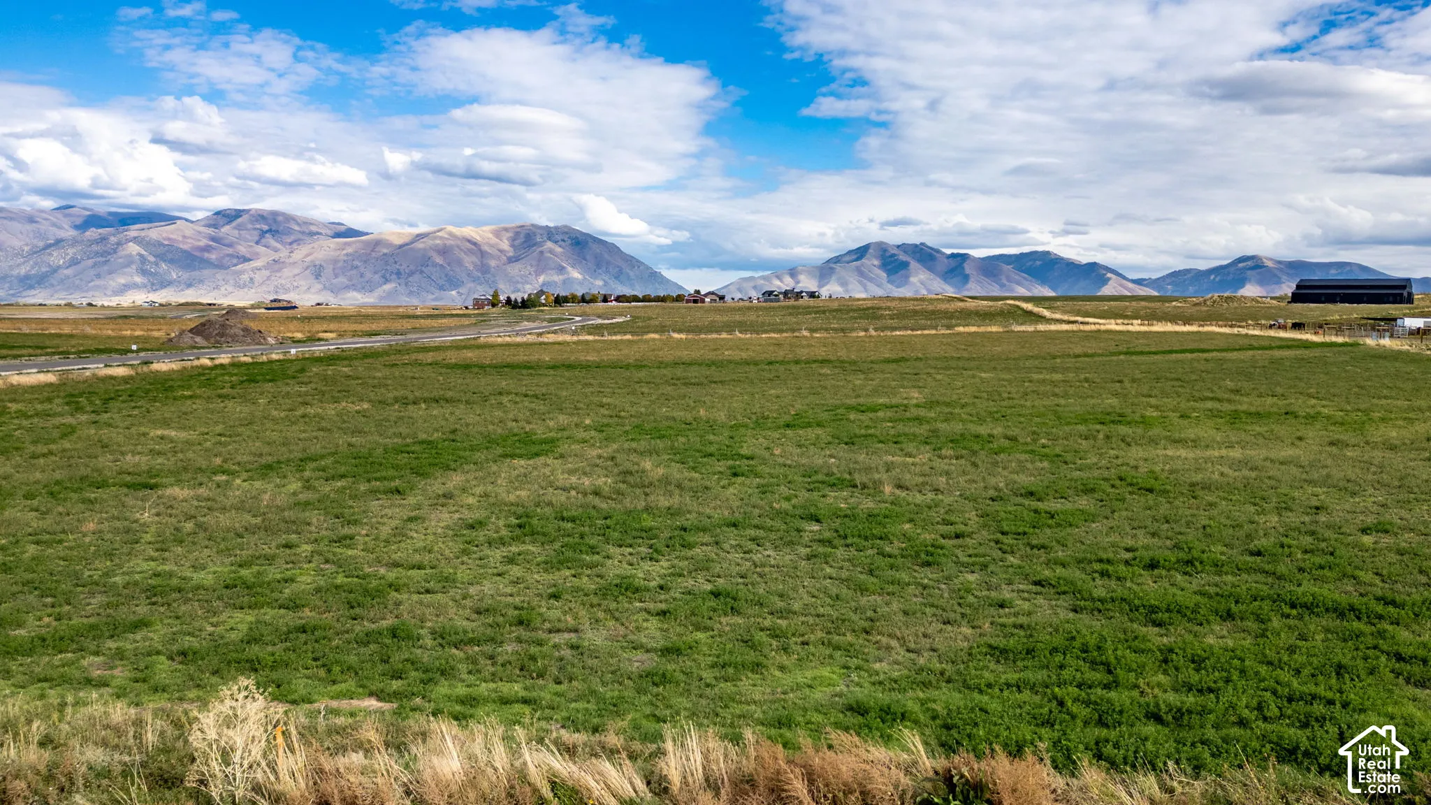 Expansive acreage featuring open green space, level terrain, and a prominent mountain backdrop
