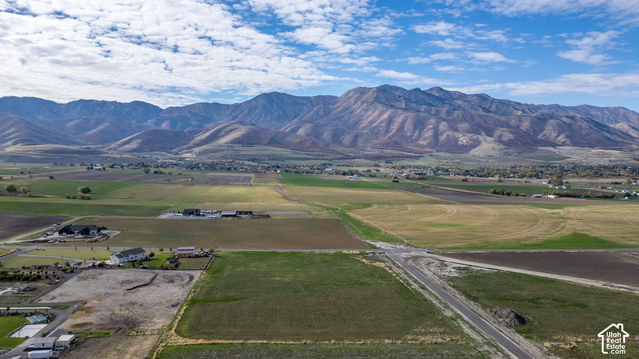 Expansive parcel of land featuring mountain backdrops, open acreage, and paved road access