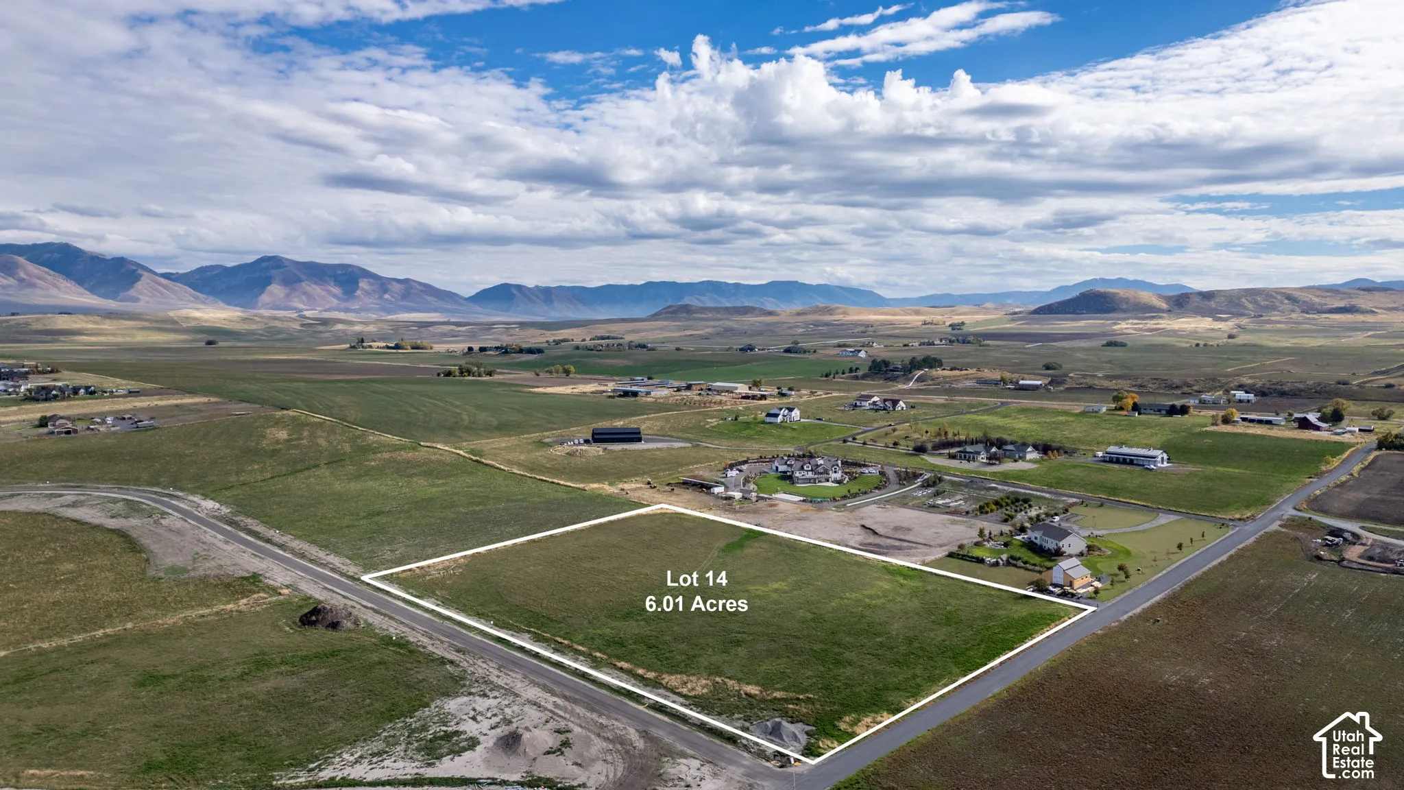 6.01-acre parcel featuring expansive open terrain, paved road frontage, and prominent mountain backdrops