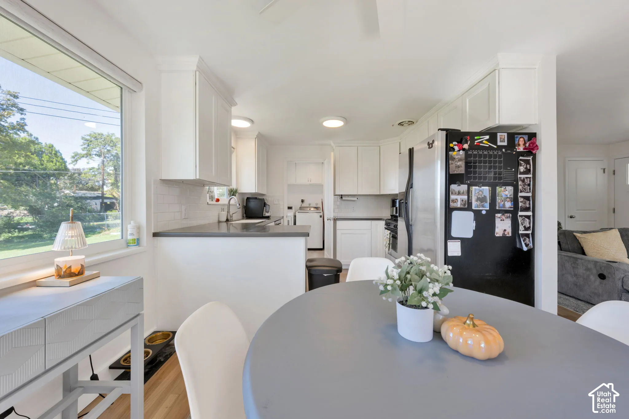 Updated Kitchen featuring white cabinetry, subway tile backsplash, dark countertops