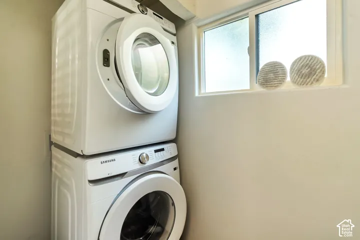 Stacked white laundry appliances featuring front-loading doors and a horizontal sliding window