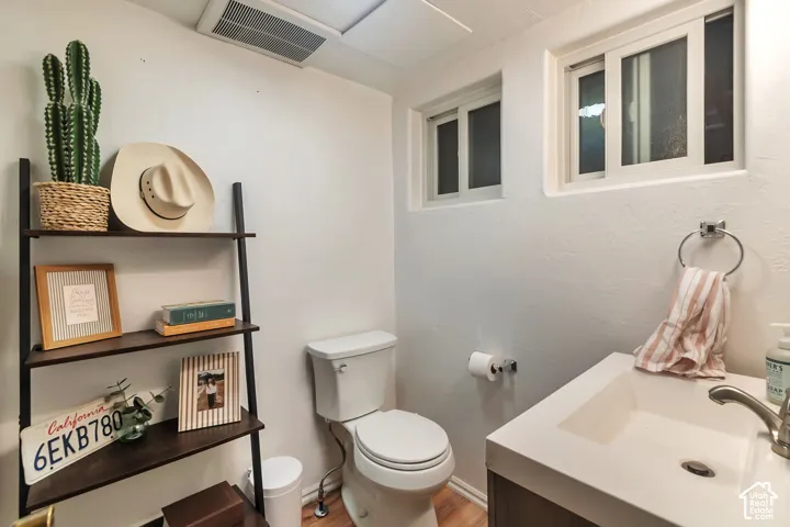 Modern vanity featuring a rectangular integrated sink with a metallic faucet, wood-finish flooring, and dual sliding windows