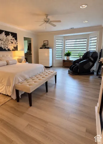 Spacious room featuring light wood-finish flooring, a prominent bay window, recessed lighting, and a ceiling fan