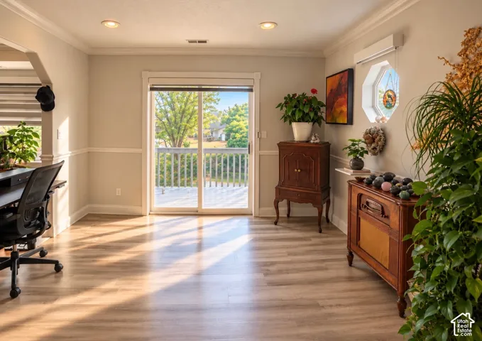 Room with wood-finish flooring, recessed lighting, crown molding, chair rail, and sliding glass door leading to an elevated exterior deck featuring an octagonal window