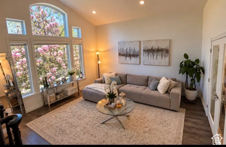 Vaulted ceilings featuring recessed lighting, large multi-pane windows with an arched transom, and wood-finish flooring