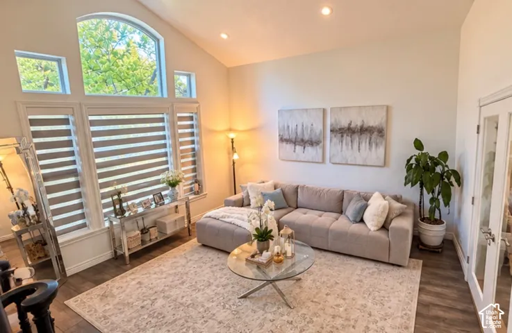 Vaulted ceilings, large multi-pane windows with arched top, wood-finish flooring, and recessed lighting