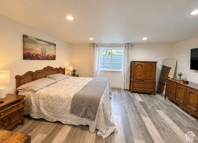 Neutral-toned room featuring wood-finish flooring and recessed lighting