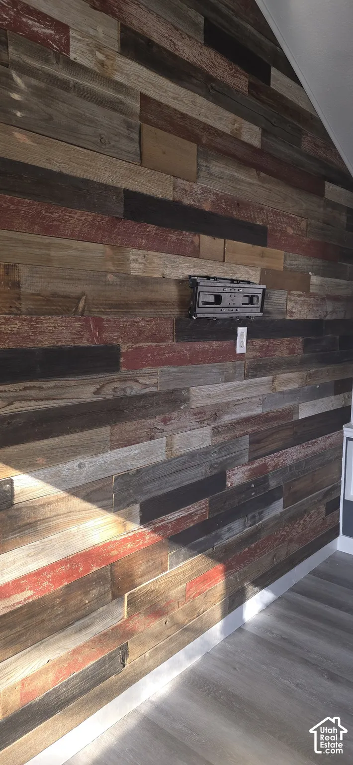 Accent wall featuring multi-toned reclaimed wood planking with integrated wall-mounted equipment bracket and electrical outlet