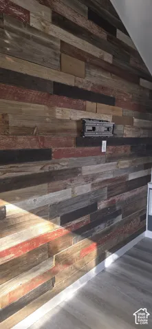 Accent wall featuring multi-toned reclaimed wood planking with integrated wall-mounted equipment bracket and electrical outlet