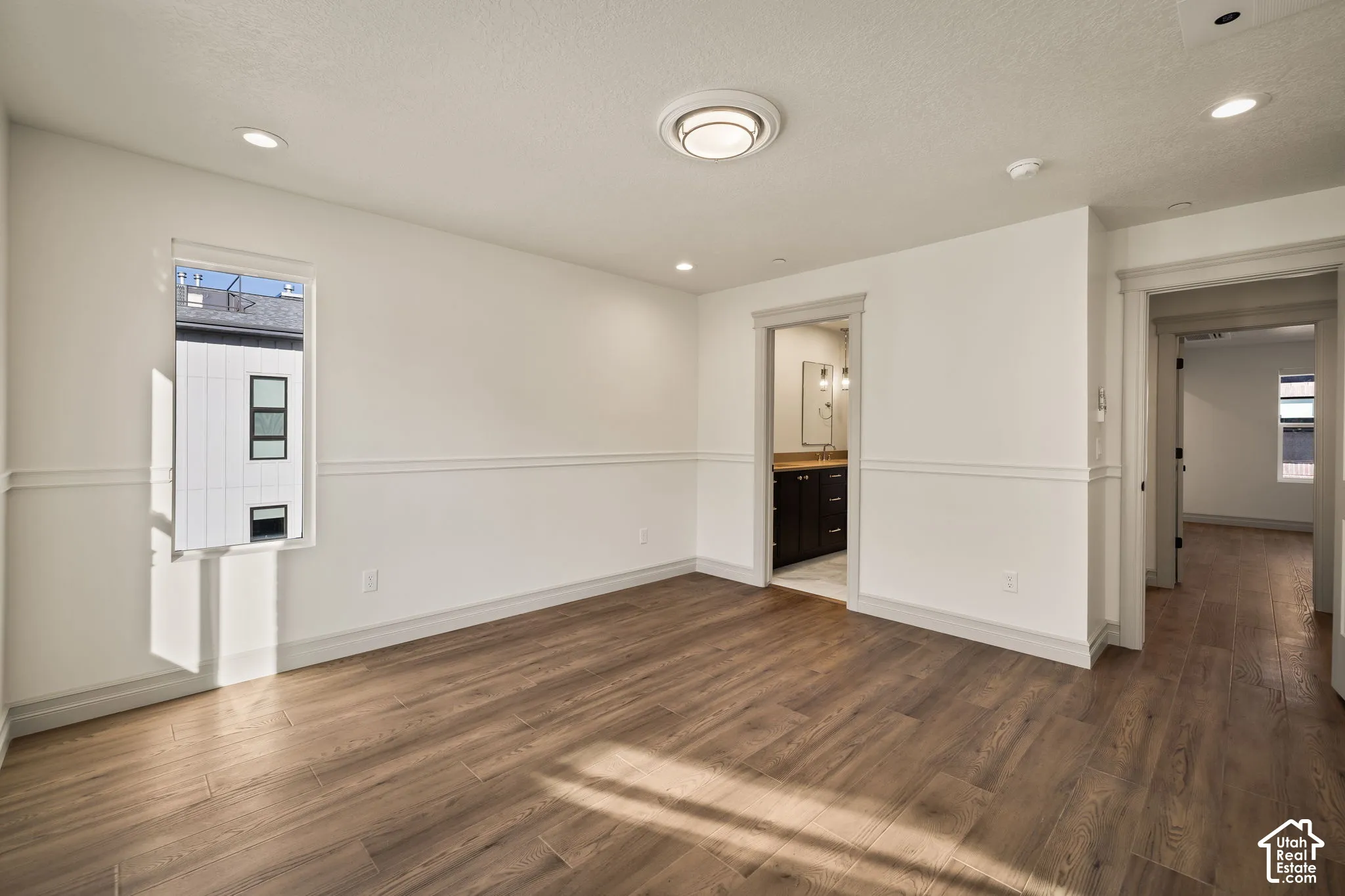 Room featuring wood-finish flooring, wainscoting, recessed lighting, and a flush-mount ceiling fixture