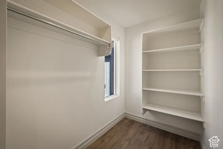 Built-in white shelving, wood-finish flooring, and a window with natural light