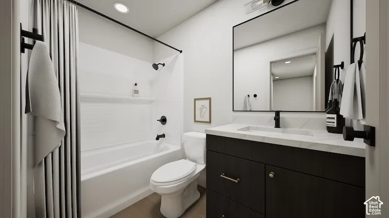 Bathroom featuring a vanity with dark cabinetry and a light-toned countertop, a rectangular undermount sink, matte black hardware, and a tub-shower combination with a tiled surround