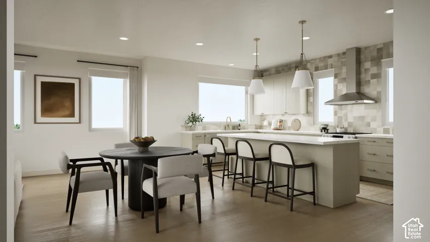 Kitchen featuring a central island with countertop seating, stainless steel range hood, stone-finish backsplash, recessed lighting, and wood-finish flooring