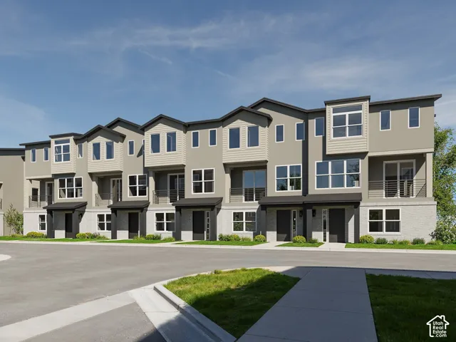 Multi-level townhome exterior featuring light brick masonry, horizontal siding, private balconies with metal railings, and multi-pane windows