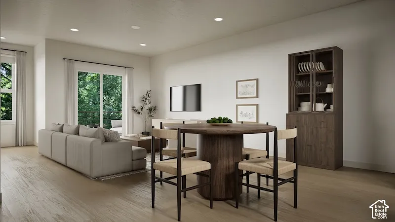 Open-concept interior featuring light wood-finish flooring, recessed lighting, and sliding glass patio doors