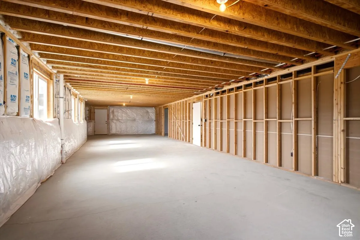 Unfinished lower level featuring exposed wood joist ceilings, concrete flooring, and structural wall framing
