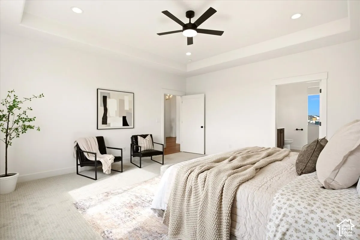 Tray ceiling with recessed lighting and a matte black integrated ceiling fan
