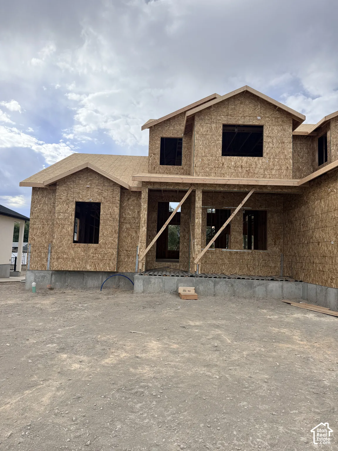 Multi-level new construction featuring a wood-sheathed exterior, concrete foundation, and multi-gable roofline