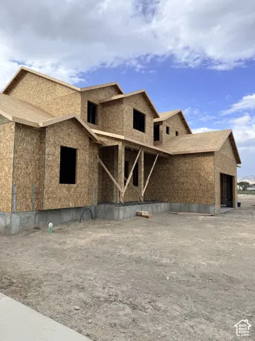Two-story new construction residence featuring oriented strand board sheathing, multi-gabled roofline, covered entryway, and attached garage