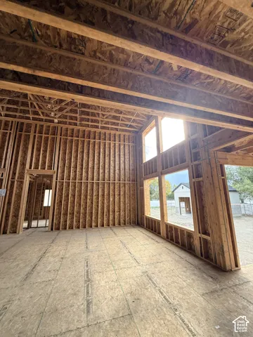 Open-concept interior framing featuring high vaulted ceilings, structural exposed timber joists, and expansive vertical window openings