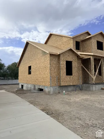 New construction property featuring a two-story framed structure with oriented strand board (OSB) exterior sheathing, a concrete foundation, and an installed concrete walkway