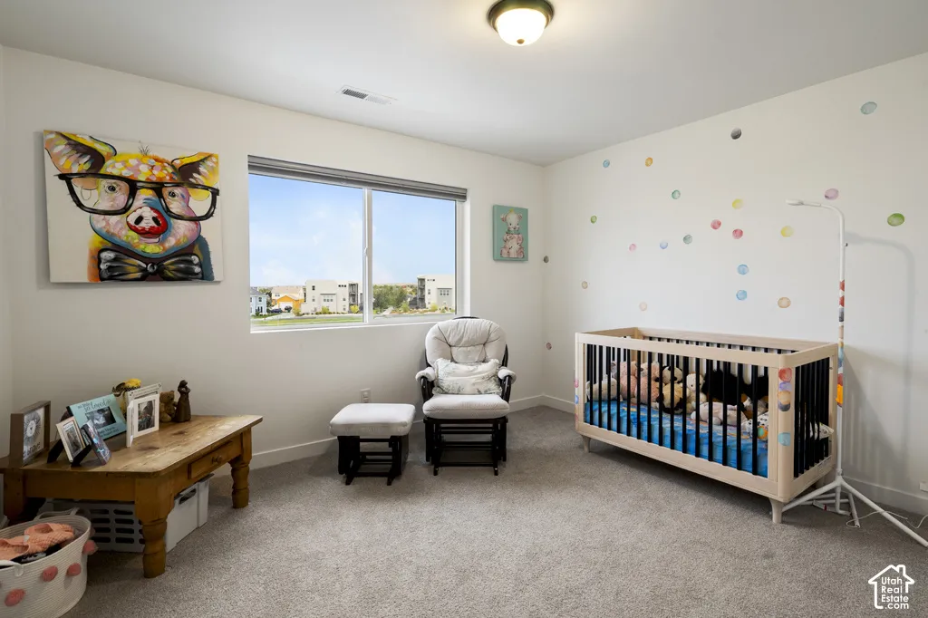 Interior space featuring neutral-toned carpeting, high-gloss white walls, and a large horizontal sliding window with natural light