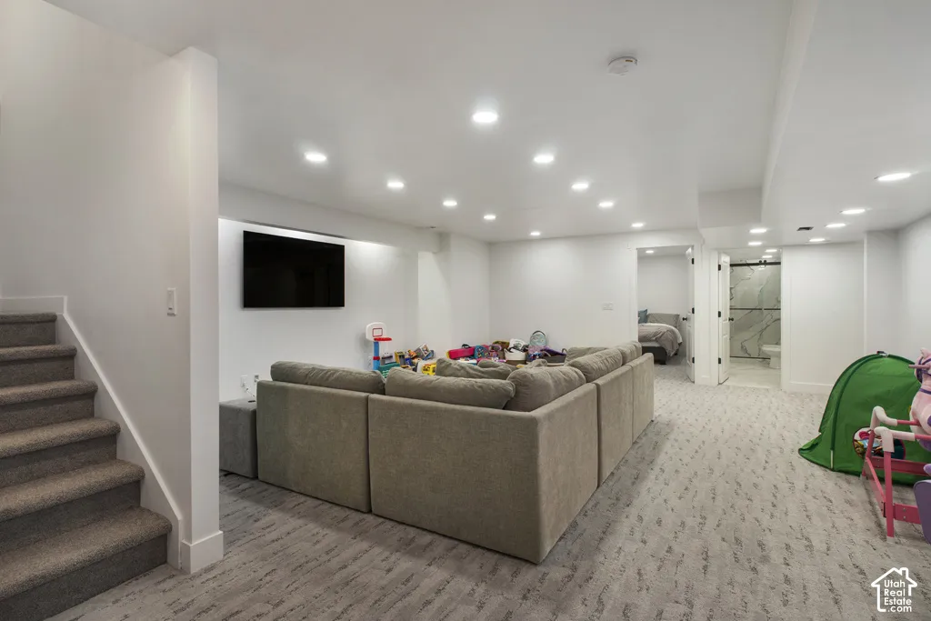 Finished lower level featuring recessed lighting, patterned carpeting, neutral wall paint, and direct access to an interior room with an en-suite bathroom