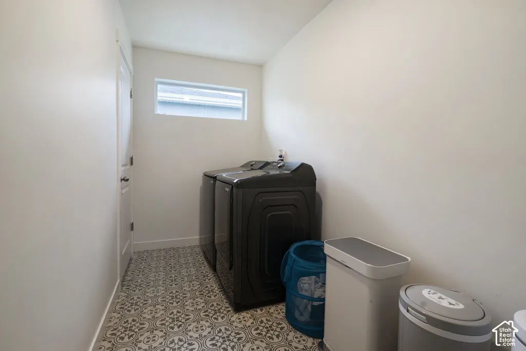 Utility area featuring patterned tile flooring, white walls, and a horizontal window