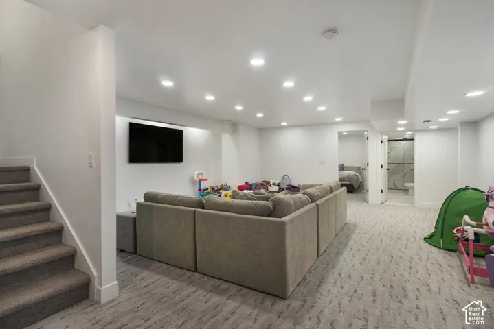 Finished lower level featuring recessed lighting, patterned carpeting, neutral wall paint, and direct access to an interior room with an en-suite bathroom