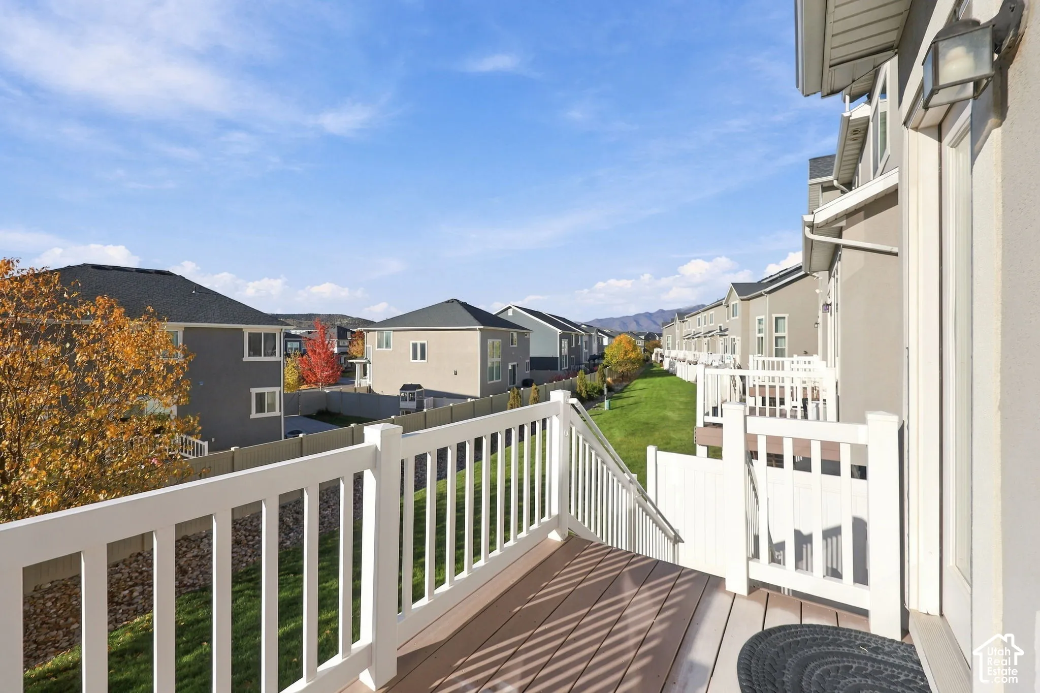 Elevated deck featuring white composite railings and neutral wood-finish decking