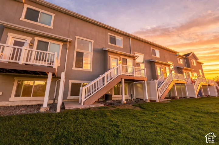 Stucco exterior featuring elevated decks with white railings, ground-level entryways, and large windows