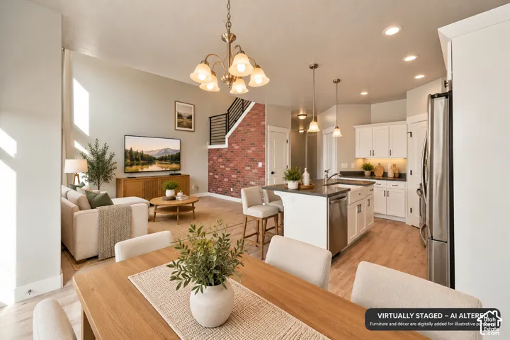 Open-concept interior featuring wood-finish flooring, a kitchen island with stone countertops, a farmhouse-style sink, and an exposed brick accent wall