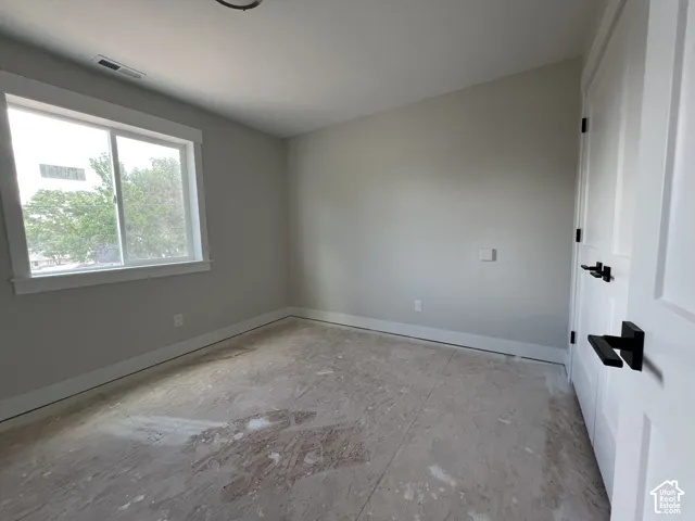 Neutral interior room featuring a sliding window, shaker-style door, and modern matte black hardware