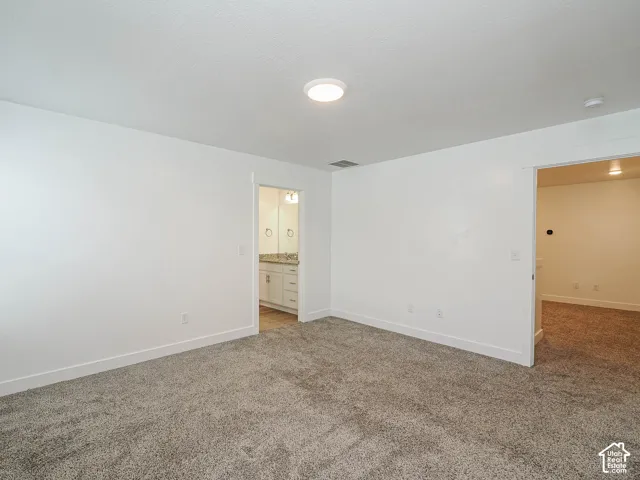 Neutral interior featuring plush wall-to-wall carpeting, crisp white walls, and a recessed ceiling light fixture