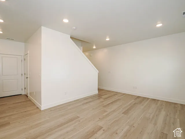 Interior space featuring light wood-finish flooring, recessed ceiling lighting, and a neutral color palette