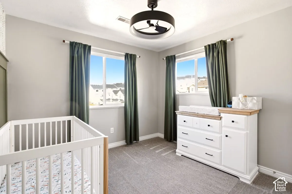 Neutral-toned walls, carpeting, dual-pane windows with sliding hardware, and a modern drum-style ceiling light fixture