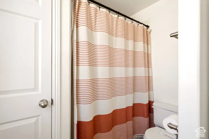 Bathroom featuring a paneled interior door, brushed metal hardware, and a wall-mounted metal towel rack