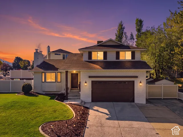 Two-story residence featuring a painted brick exterior, bay window, two-car garage, and concrete driveway