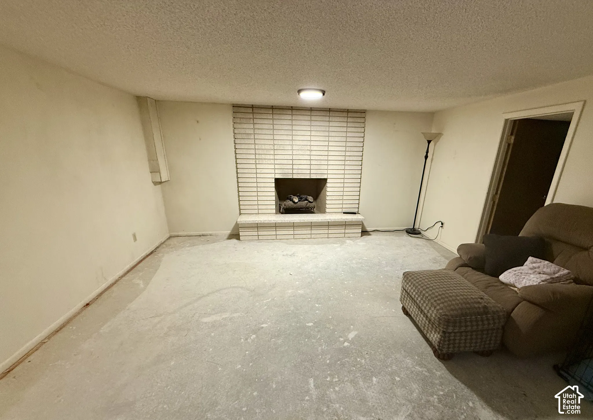 Floor-to-ceiling brick fireplace surround with an integrated masonry hearth and flush-mount ceiling lighting