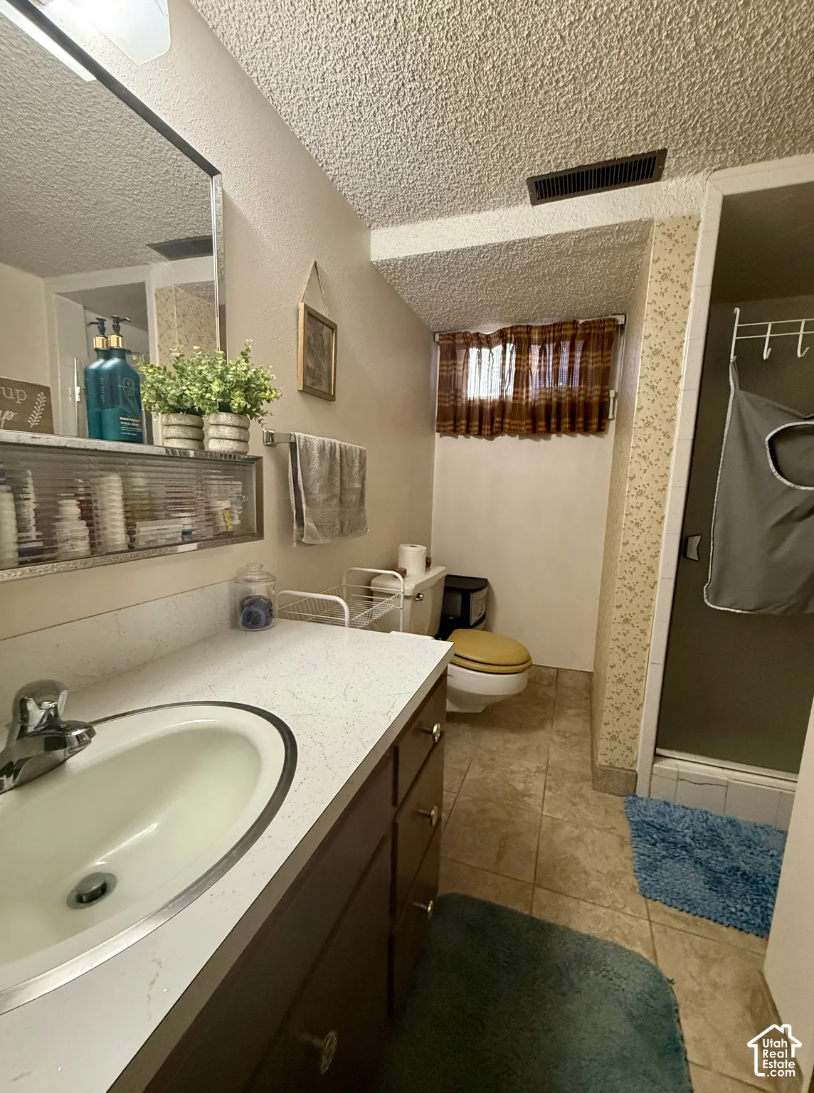 Bathroom featuring an integrated oval sink, built-in vanity cabinetry with drawer storage, and a separate stall shower