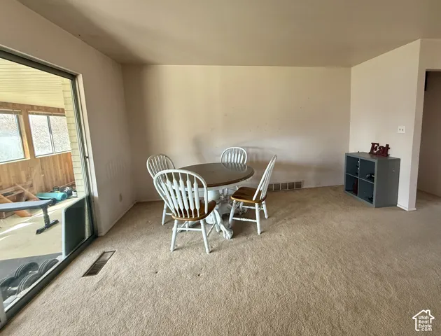 Neutral-toned carpeted flooring, sliding glass door, and exterior room access
