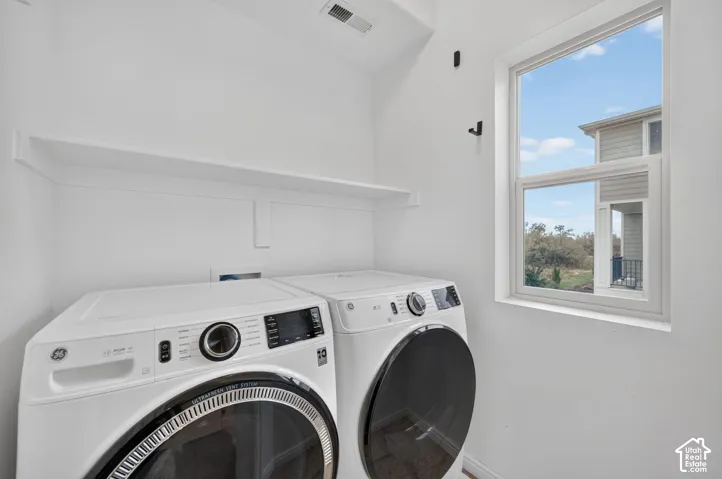 Laundry area featuring a single-hung window, built-in shelving, and white walls
