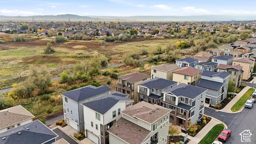Aerial perspective featuring multi-level residential structures, asphalt paving, and expansive open space