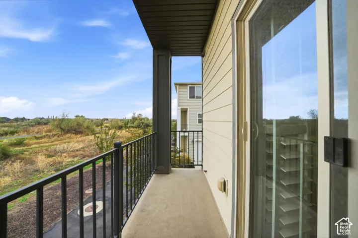 Covered balcony featuring horizontal lap siding, concrete flooring, and metal railings